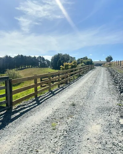 Post and rail fence lining a farm driveway in North Auckland