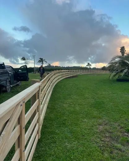 Curved post and rail fence built by Elite Lifestyle Services under a Rodney sky